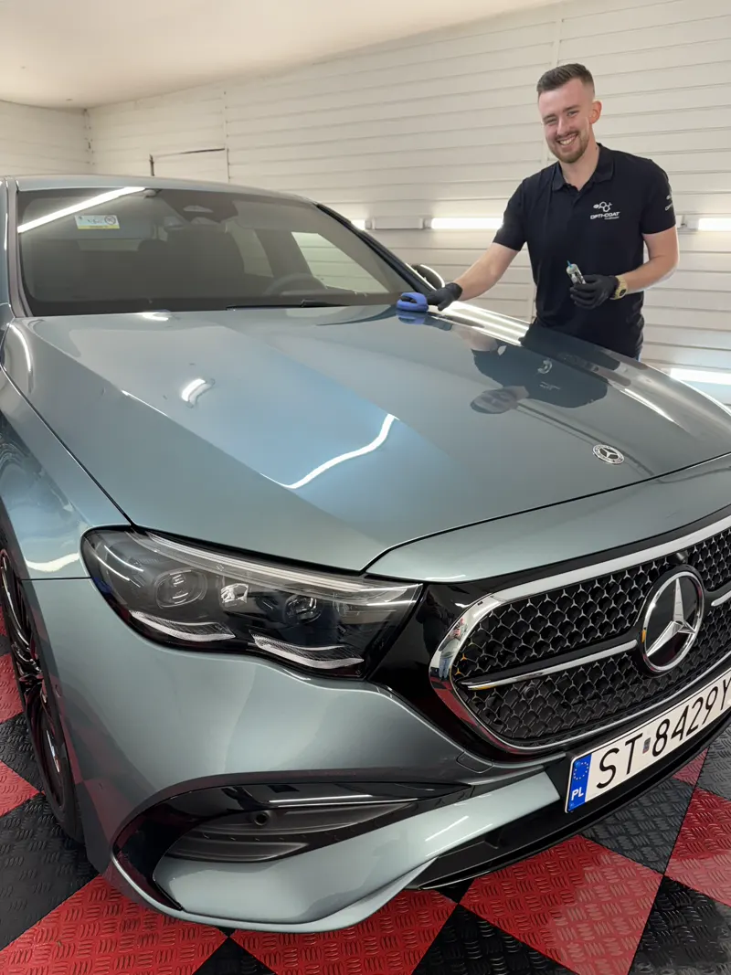 Detailer Steam Wash w koszulce Opti-Coat nakłada powłokę na maskę Mercedesa w studiu